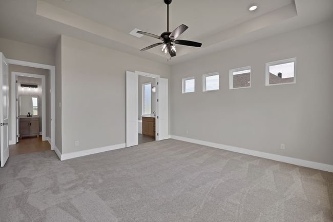 Unfurnished bedroom with a tray ceiling, carpet flooring, and ensuite bathroom | Image 17