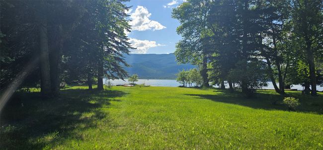 View of grassy yard featuring a water and mountain view | Image 8