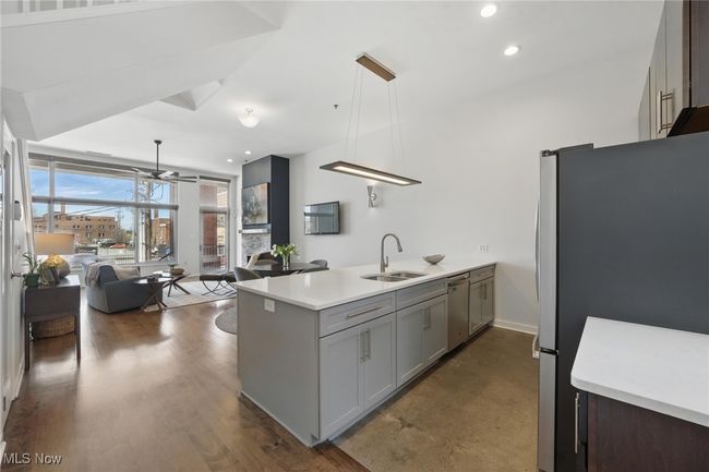 Kitchen featuring stainless steel appliances, a ceiling fan, a sink, a peninsula, and open floor plan | Image 14
