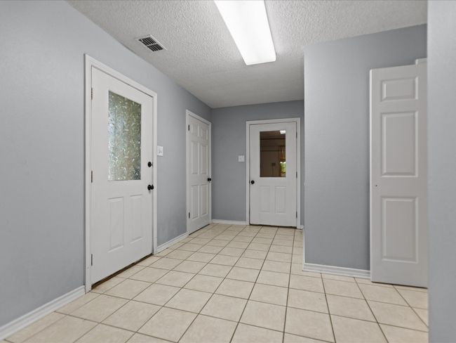 Mudroom with a textured ceiling and baseboards | Image 21