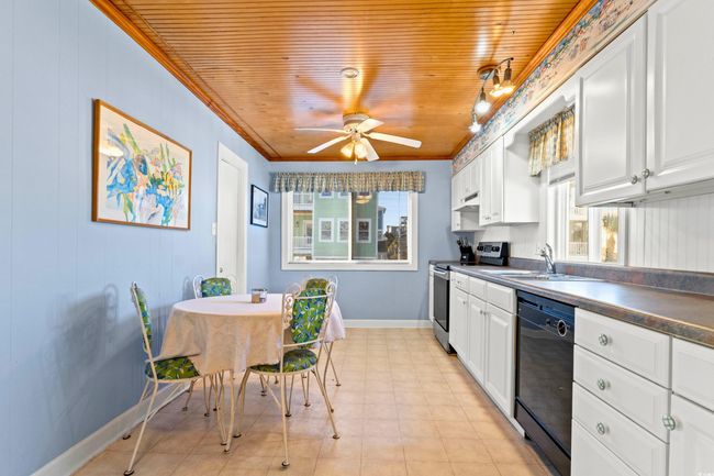 Kitchen with white cabinetry, stainless steel electric range oven, dishwasher, sink, and ornamental molding | Image 15