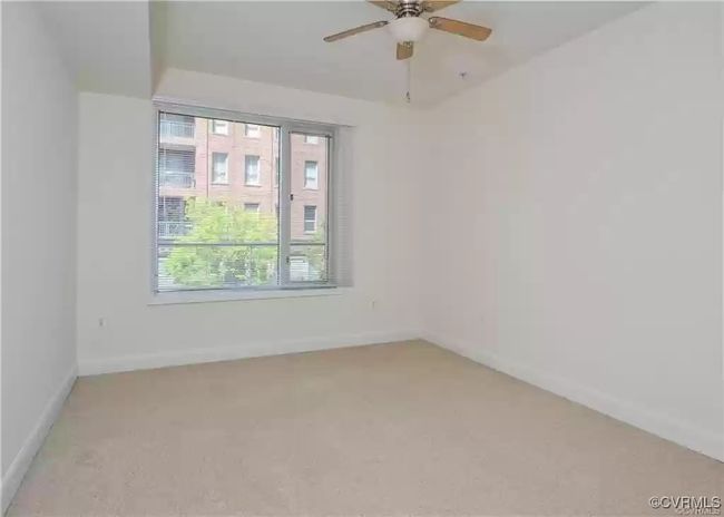 Spare room featuring light carpet, baseboards, and a ceiling fan | Image 11