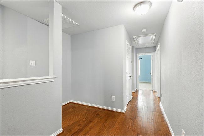 Corridor with baseboards, attic access, and hardwood / wood-style floors | Image 22