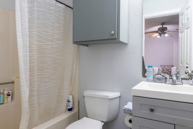 Bathroom featuring vanity, toilet, shower / bath combo with shower curtain, and a ceiling fan | Image 14
