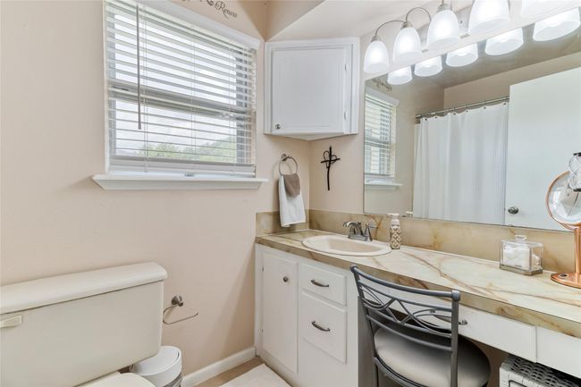 Primary bathroom features a convenient vanity area, a window that brings in natural sunlight & a low-profile tub/shower combo for easy accessibility & added comfort. | Image 13