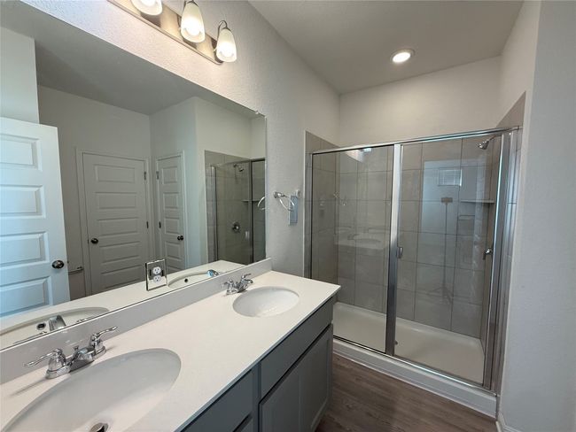 Full bath with wood finished floors, a shower stall, and double vanity | Image 16