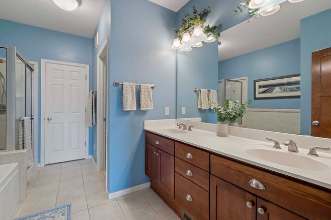 Primary bath with dual sinks, separate tub and shower and large walk-in closet. | Image 13