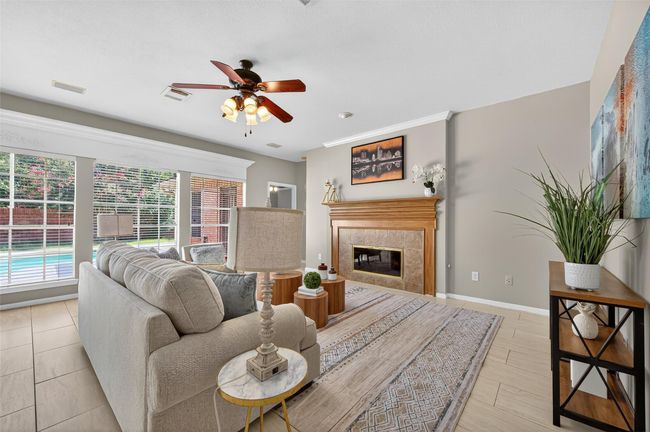 Charming brick home with mature trees providing shade and a well-maintained lawn. The property features a fenced backyard and a detached garage, offering ample parking space. Ideal for buyers seeking a peaceful, suburban setting. | Image 6