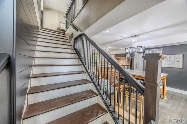 Staircase featuring a chandelier, wood finished floors, and recessed lighting | Image 34