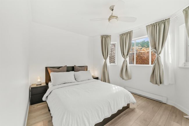 Bedroom with baseboards, ceiling fan, baseboard heating, and light wood-style floors | Image 15