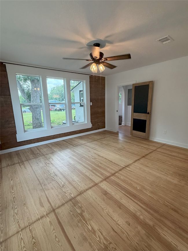 Unfurnished living room featuring light wood-type flooring and a ceiling fan | Image 10