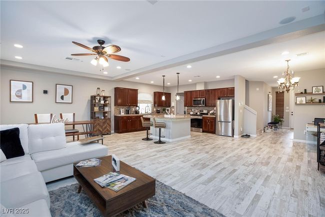 Living area featuring recessed lighting, light wood-style flooring, visible vents, and ceiling fan with notable chandelier | Image 12