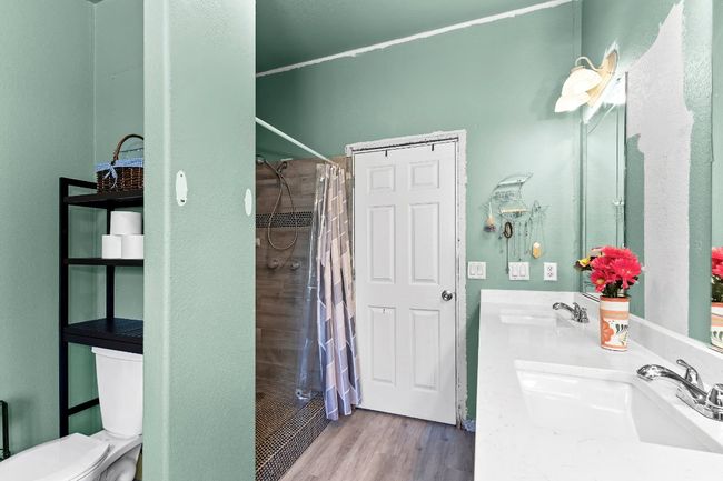 Bathroom with a walk-in tiled shower, double vanity, toilet, and new vinyl flooring | Image 15