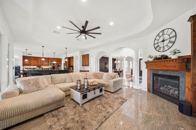 This open & flowing floor plan offers seamless movement from one room to another. This is a view of the living room with the breakfast room & kitchen in the background. | Image 10