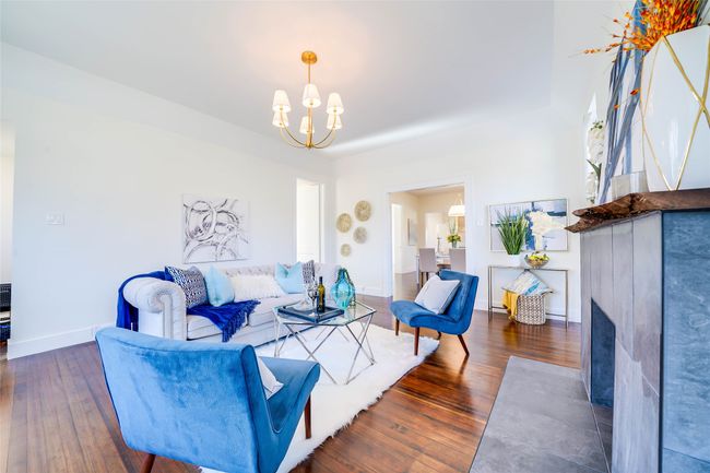 Living room with dark wood-type flooring and a notable chandelier | Image 9