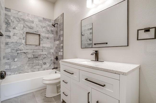 Bathroom featuring vanity, tile patterned flooring, toilet, and shower / washtub combination | Image 30