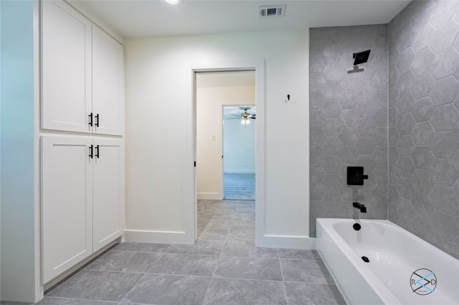 Bathroom featuring tiled shower / bath combo and tile patterned floors | Image 15