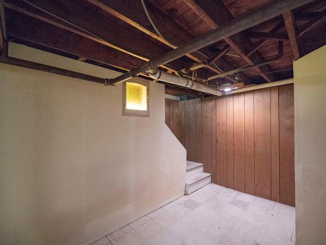Basement with stairway, wood walls, and tile patterned floors | Image 34