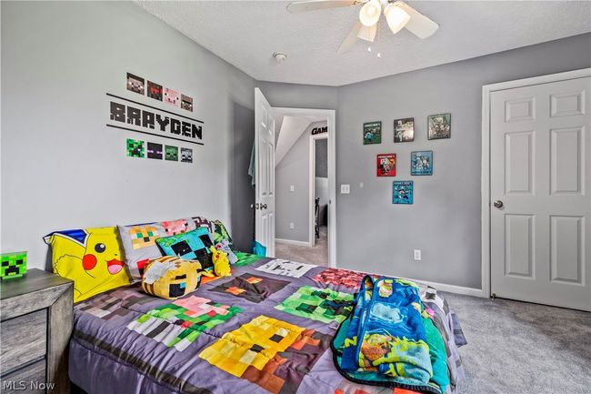 Bedroom with a textured ceiling, carpet flooring, and ceiling fan | Image 30