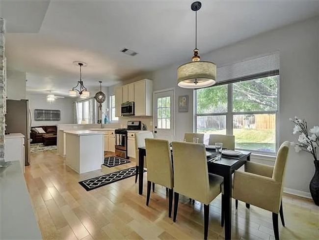 Dining room with light wood-style flooring and a ceiling fan | Image 12