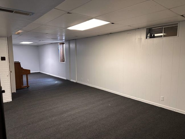 Finished below grade area featuring carpet floors, visible vents, and a drop ceiling | Image 12