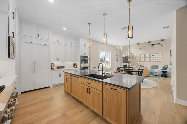 Kitchen featuring light wood-type flooring, ceiling fan, stainless steel appliances, a kitchen island with sink, and recessed lighting | Image 9