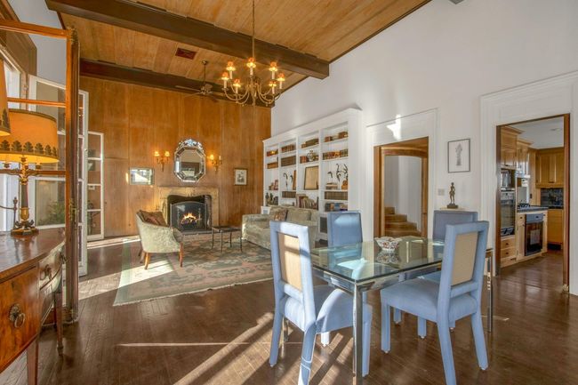 Dining space featuring beam ceiling, wooden walls, wood ceiling, dark hardwood / wood-style flooring, and ceiling fan with notable chandelier | Image 16