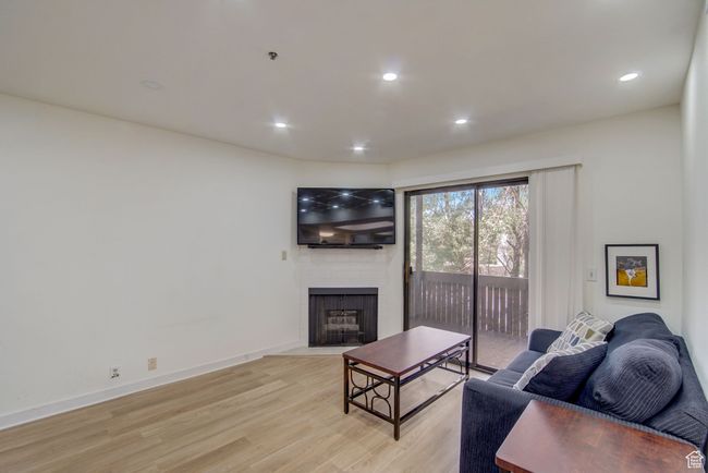 Living room with light wood-type flooring and a fireplace | Image 6