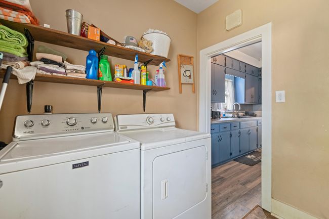 Laundry room featuring washer and clothes dryer and light wood-type flooring | Image 33