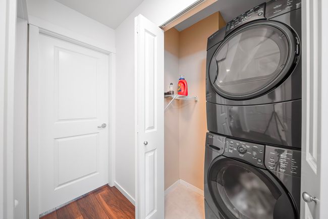 Laundry room featuring dark wood-type flooring, laundry area, baseboards, and stacked washer / drying machine | Image 29