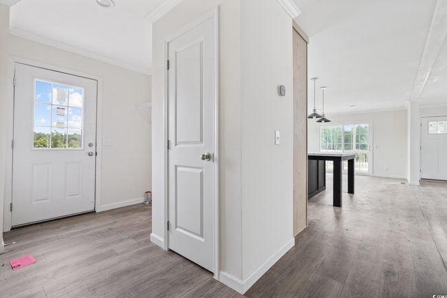Hallway featuring crown molding and wood finished floors | Image 4