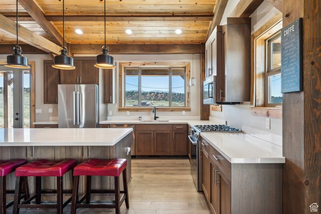 Kitchen with appliances with stainless steel finishes, wood ceiling, light countertops, and a sink | Image 30