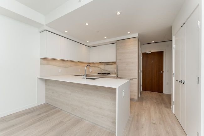 Kitchen with a sink, light countertops, light wood-style flooring, and modern cabinets | Image 5
