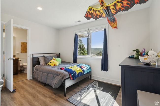 Bedroom with wood finished floors, ensuite bathroom, and recessed lighting | Image 26