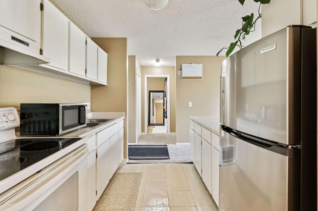 Stylish white cabinetry and some SS appliances. Neutral colors throughout makes this one move in ready. | Image 5