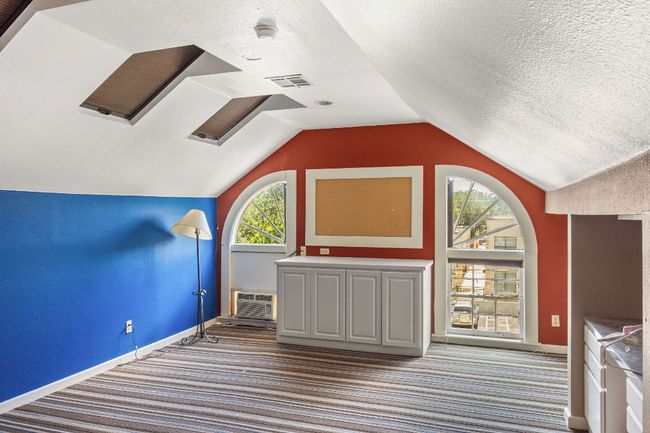 Bonus room featuring carpet, lofted ceiling, a textured ceiling, and an AC wall unit | Image 28