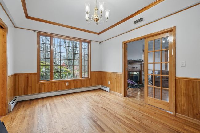 Unfurnished room with a baseboard heating unit, visible vents, and a wainscoted wall | Image 21