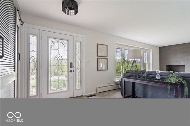 foyer featuring baseboard heating, baseboards, and carpet flooring | Image 4