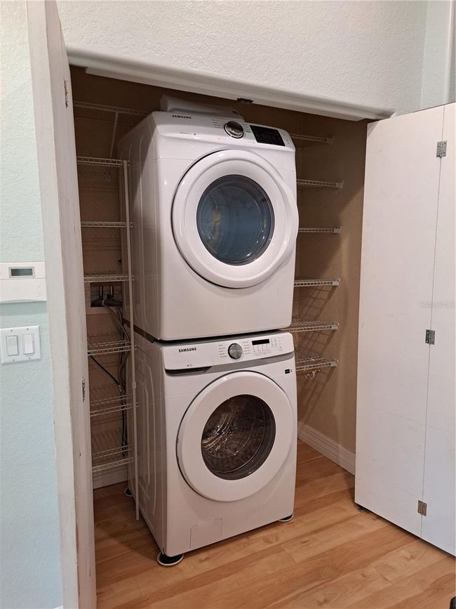 Laundry closet with stacking washer and dryer. Pantry space for food and cleaning supplies. This is located inside in main Living area. | Image 21