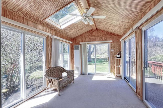 Sunroom / solarium featuring a ceiling fan and a skylight | Image 13