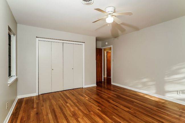 Unfurnished bedroom featuring wood finished floors, a closet, and a ceiling fan | Image 20