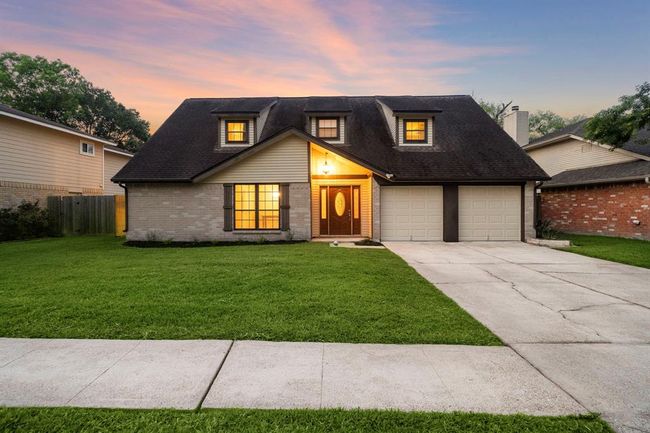Double-wide driveway leads to an attached 2-car garage with extra storage, providing plenty of parking and direct entry to the home. Spacious front yard offers tidy landscaping, while the walkway welcomes guests to a covered front porch entry. | Image 6