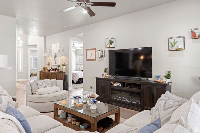 Living area featuring a ceiling fan and wood finished floors | Image 52