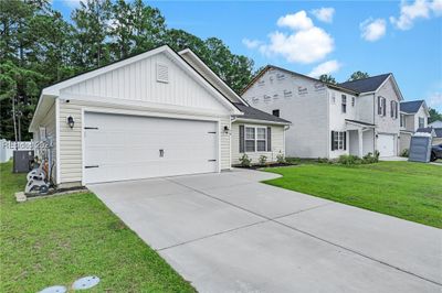 View of front facade with a garage and a front yard | Image 3