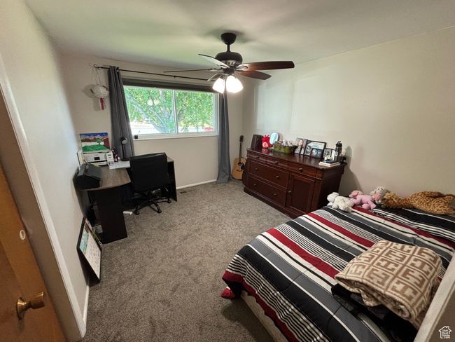 Carpeted bedroom featuring a ceiling fan and a desk | Image 11
