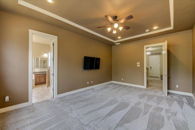 Primary Suite with a raised ceiling, light carpet, and recessed lighting | Image 17