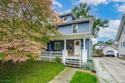 View of front of house featuring a garage, a front lawn, and a porch | Image 1