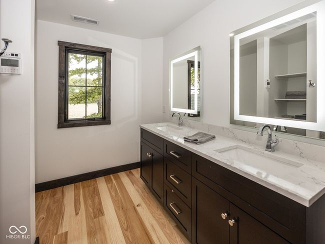 bathroom with double vanity, wood finished floors, and baseboards | Image 34