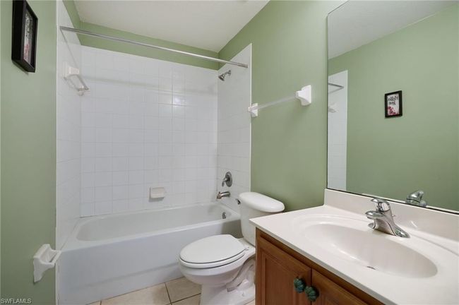 Bathroom with vanity, tile patterned floors, and bathtub / shower combination | Image 11