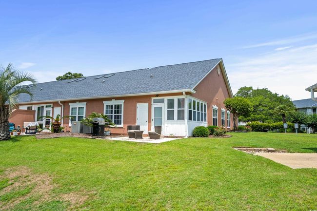 Rear view of property with a patio area, a shingled roof, a yard, and stucco siding | Image 22